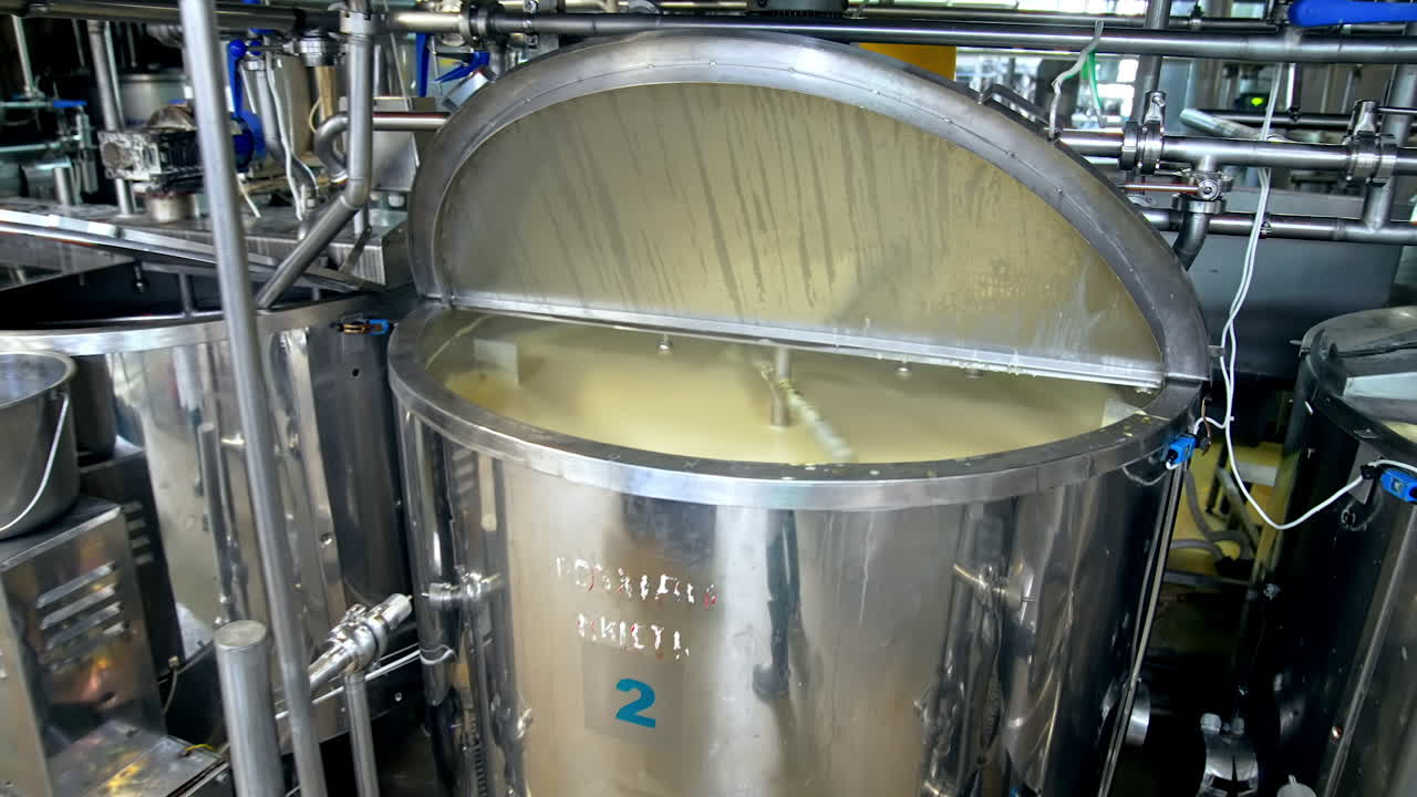Looking inside the large cistern full of sour cream which is being automatically mixed. Close look at the dairy tank with gradual distancing from it.