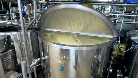 looking inside the large cistern full of sour cream which is being automatically mixed. close look at the dairy tank with gradual distancing from it.