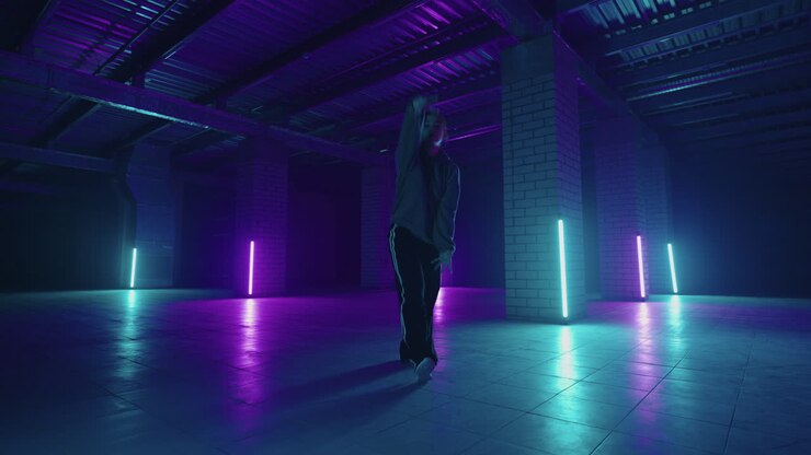 Una donna balla hip-hop freestyle in uno stile moderno in una sala con luci al neon nei colori viola e blu. Ballerina professionista di hip hop.
