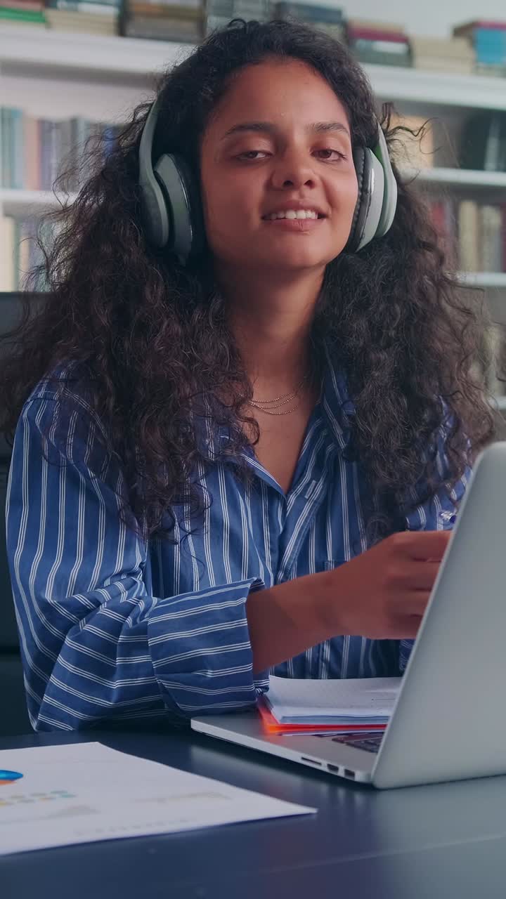 Young woman enjoying music while working in a cozy environment
