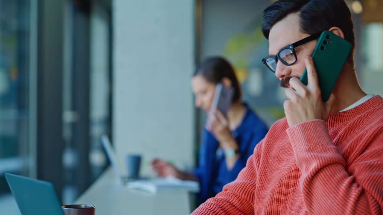 Multitasking employees talking smartphones in coworking workplace closeup