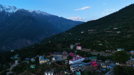 una fotografía aérea de las casas de madera tradicionales de kalpa frente al poderoso kinner kailash.