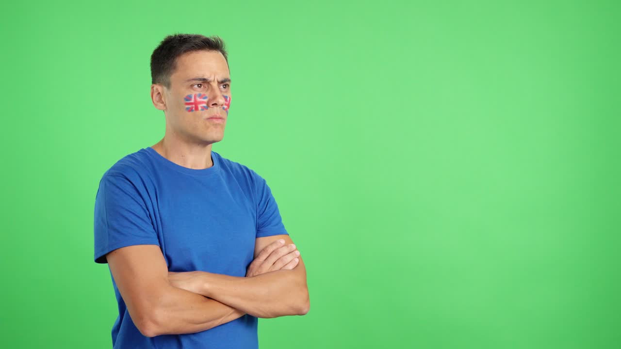 Man with british flag painted looking away with serious expression
