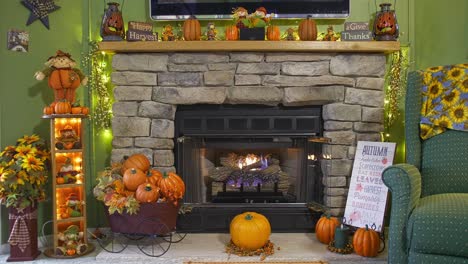 a view of a fireplace with a fire, all decorated for autumn with pumpkins, scarecrows and fall leaves