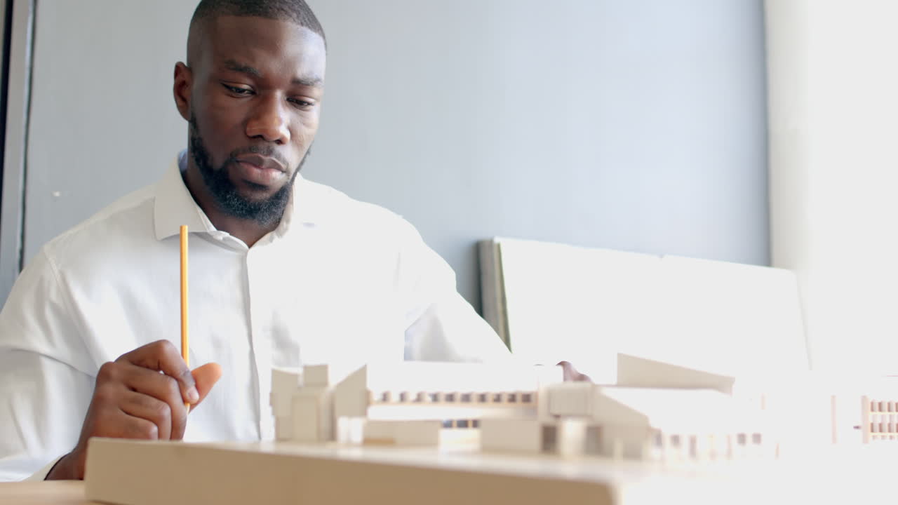 Architect working on building model, focusing on design details in office, copy space