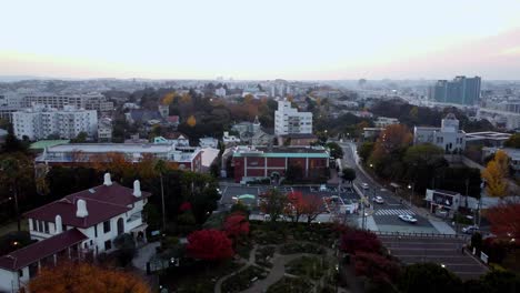 A-tranquil-town-during-autumn-twilight-with-colorful-foliage,-aerial-view