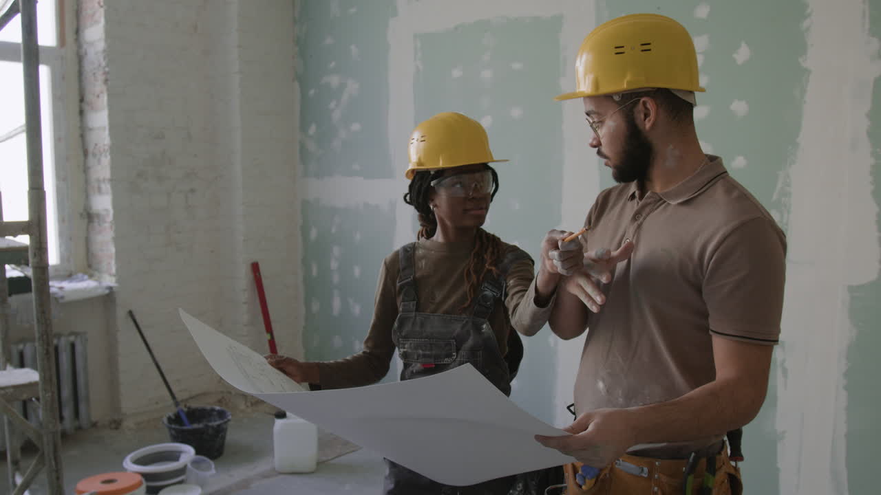 Construction Team Reviewing Blueprints During Renovation