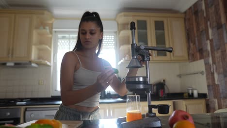 mujer haciendo jugo de naranja en la cocina