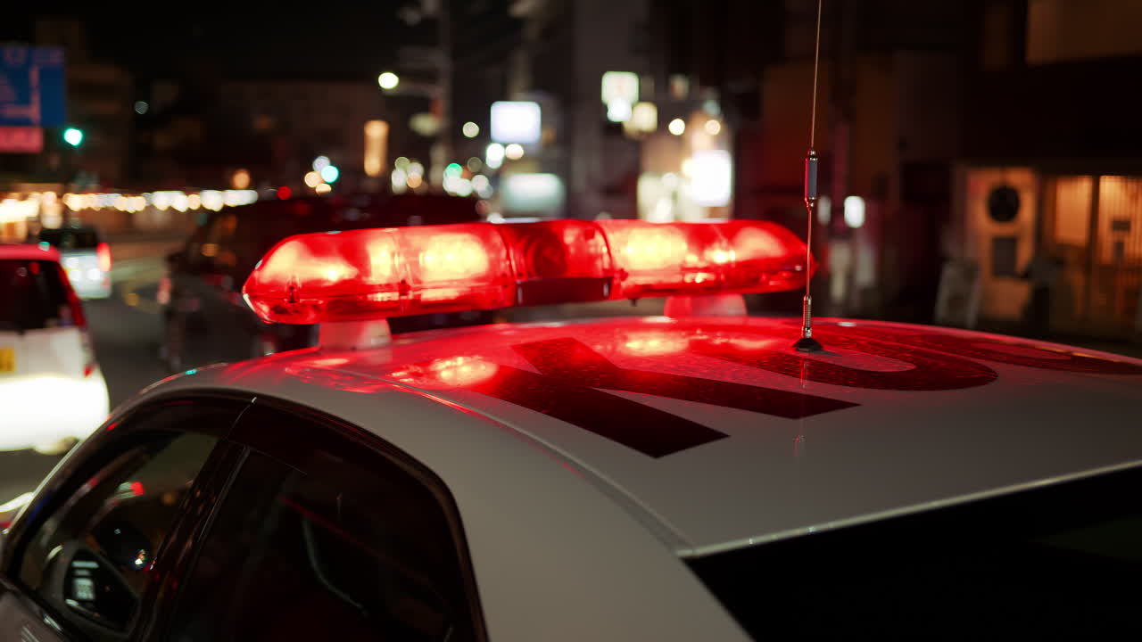 Close up of red police lights on top of a car in the Gion area in the evening in Kyoto, Japan
