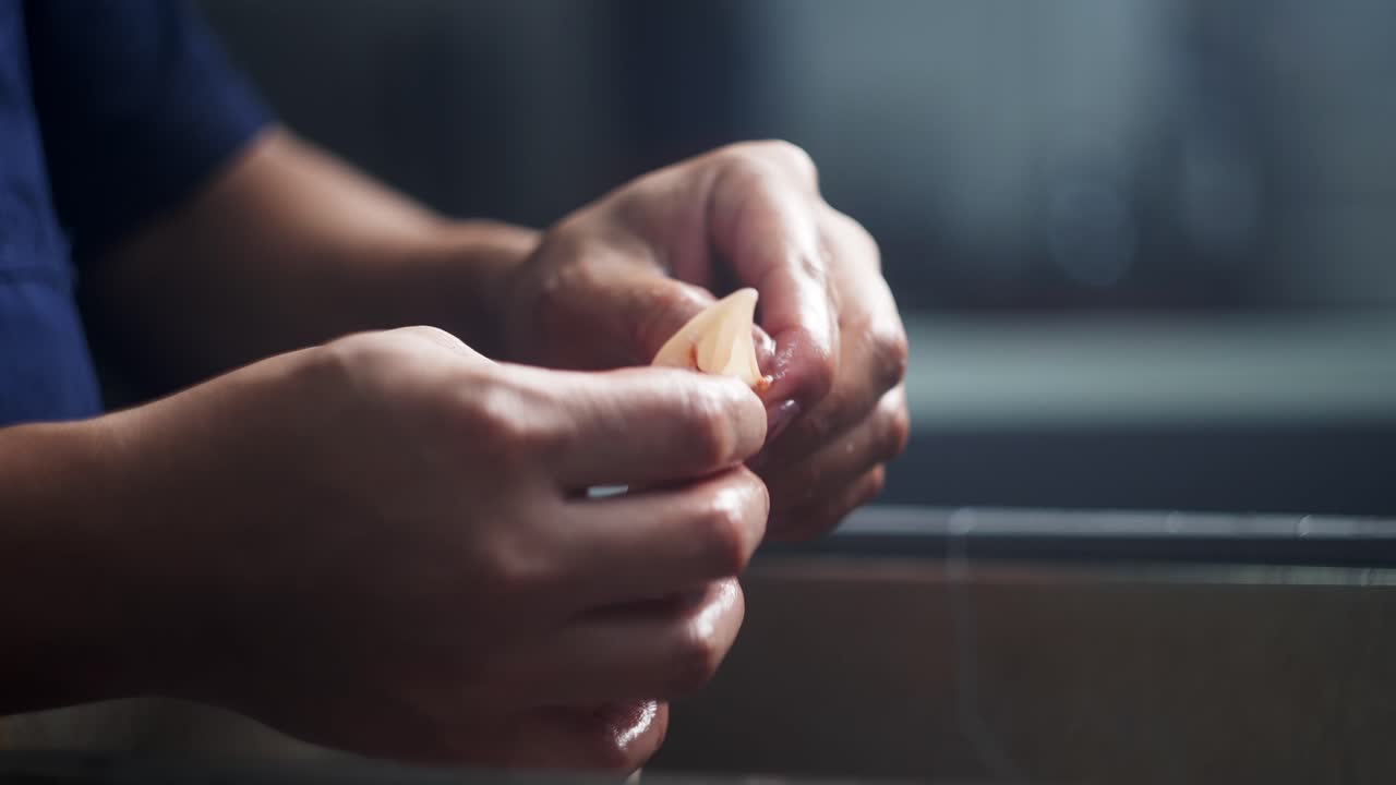 Close up and unique perspective of Chef's hands cleaning fresh squid under cinematic atmosphere in a restaurant kitchen.