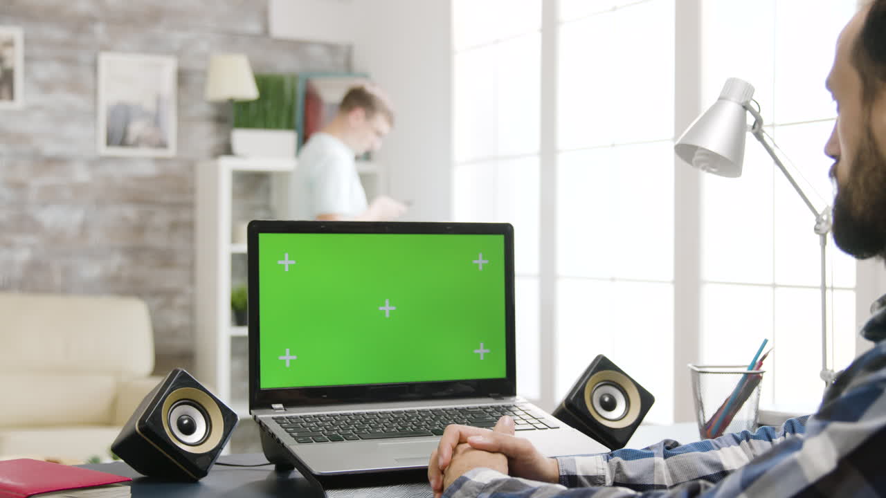 portátil con pantalla verde en el escritorio