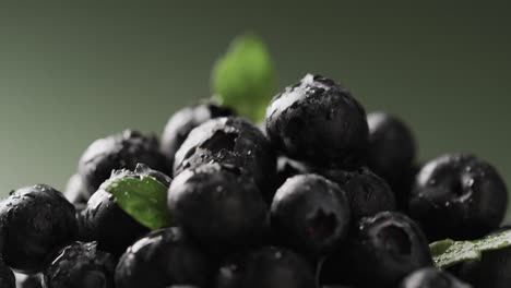 Micro-video-of-close-up-of-blueberries-with-copy-space-on-green-background