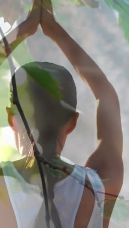 animation of leaves over caucasian woman practicing yoga and meditating