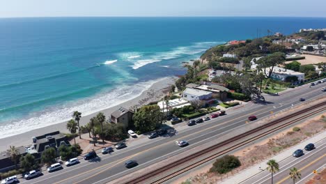 drone shot flying over a road leading to a beautiful beach in encinitas, california