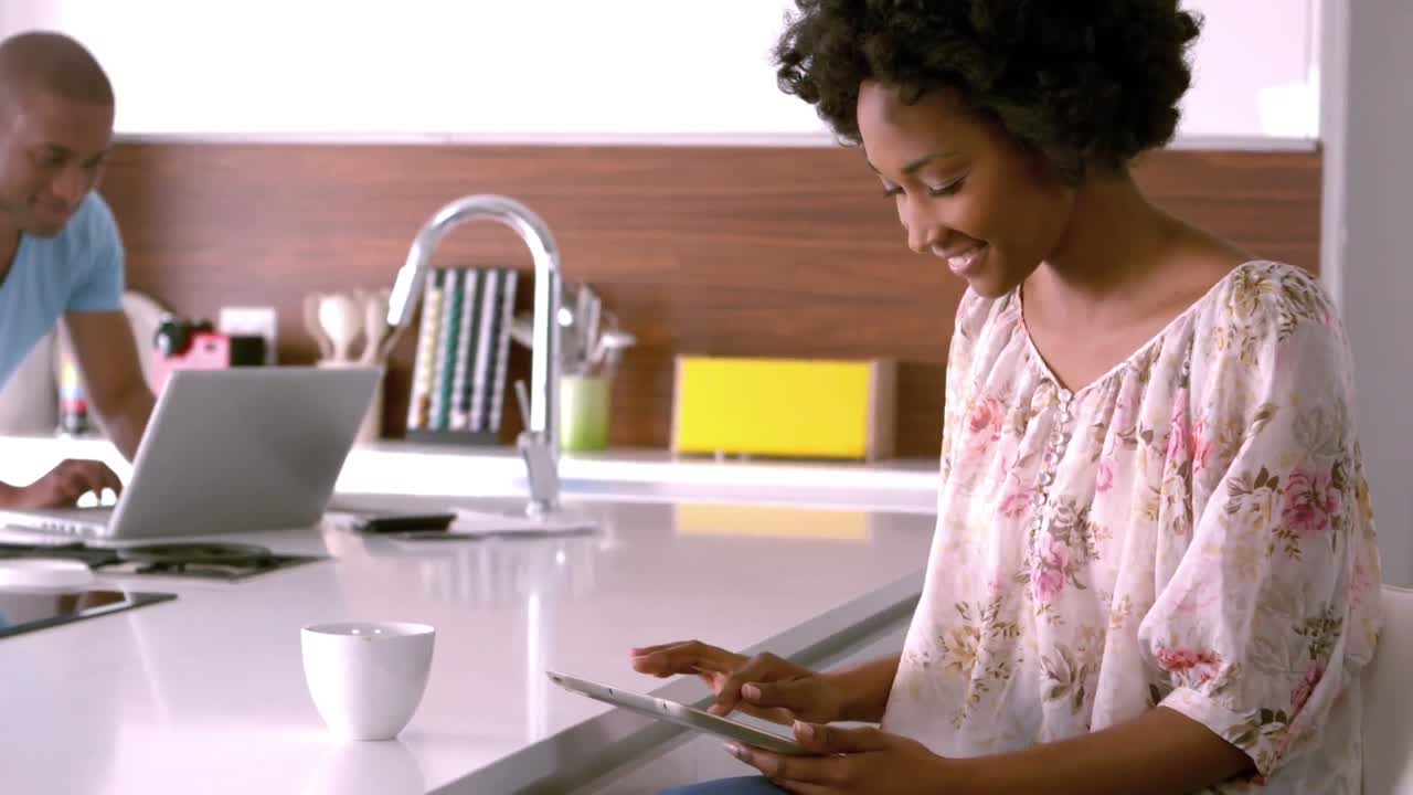 pareja sonriente usando tableta y computadora portátil