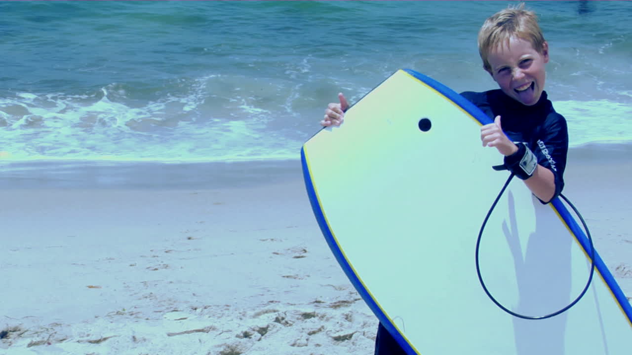 해변의 소년이 몸짓을 하고 얼굴을 만든다