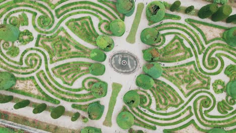 Cinematic-spinning-aerial-of-beautiful-romantic-maze-garden-with-fountain