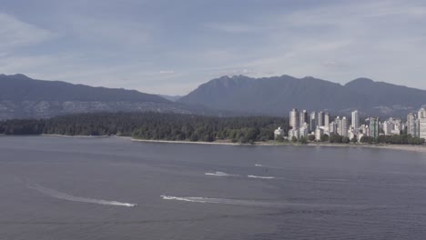 Luftflug-über-Den-Strand-Von-Kitsilano-Zum-Englischen-Bay-Stanley-Park,-Während-Freizeitmotorboote-An-Segelbooten-Vorbeifahren,-Geparkte-Menschen,-Sich-Sonnen,-Angeln,-Umarmen-Und-Romantische-Entspannung-An-Einem-Heißen-Sommertag-In-BC-1-4