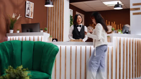 asian guest signing check in papers on tablet at reception