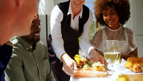 smiling waitress serving food to customers