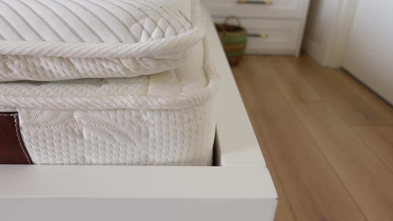 Close up of a modern white bed frame and mattress