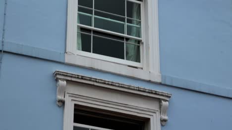 classic window frame style of light blue house at notting hill in london, united kingdom