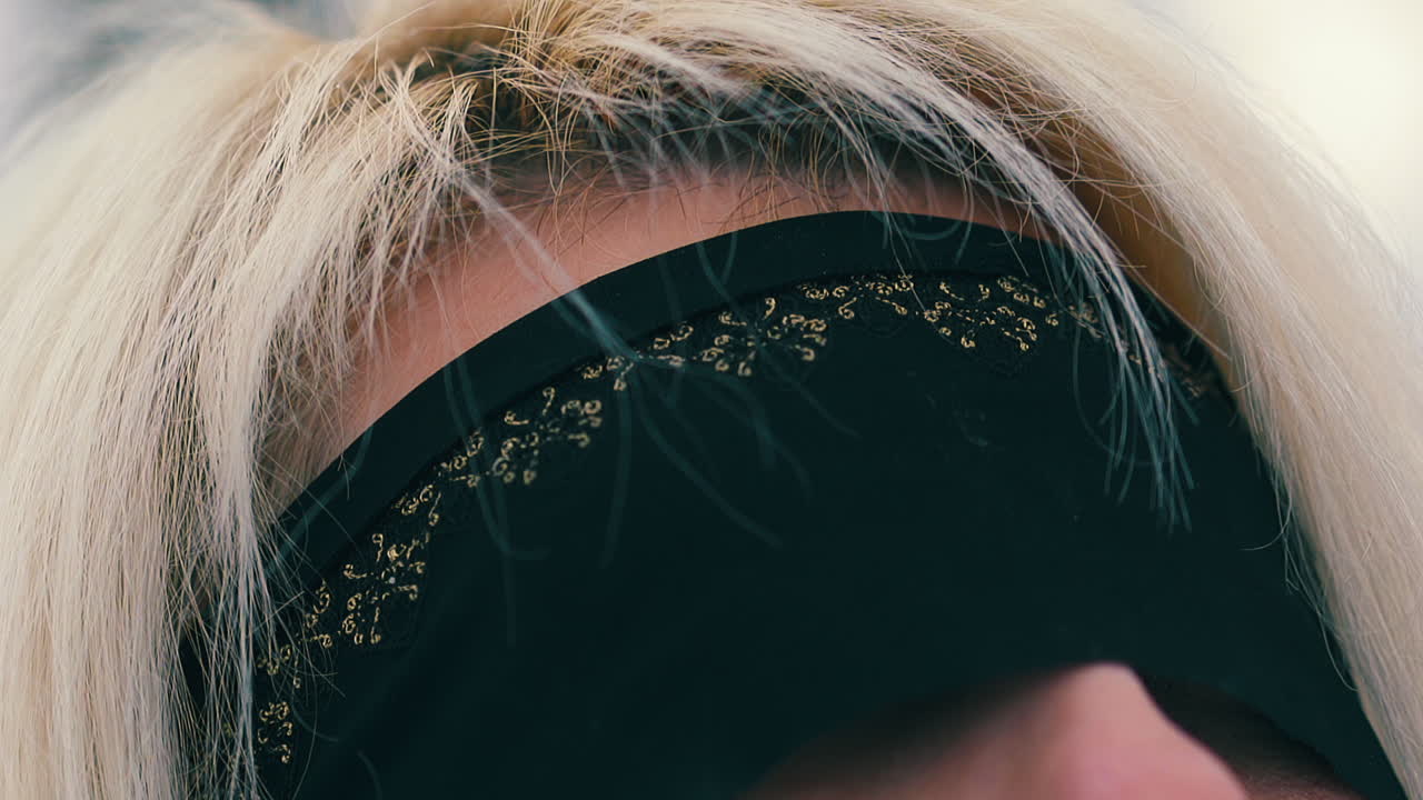 겨울 숲에서 얼굴에 검은 눈가리개를 한 금발의 여자