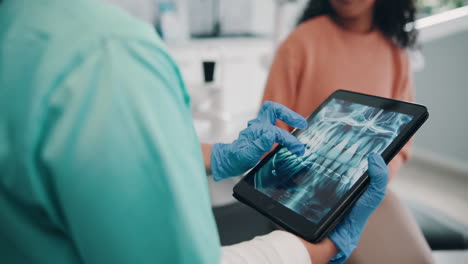 dentist showing a patient their dental x-ray on a tablet