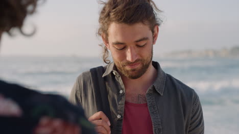 handsome-young-man-posing-for-photo-on-sunny-beach-friend-taking-photos-using-smartphone-camera-vacation-travel-memories-real-people-series