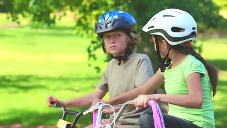 young girl cycling with her brother