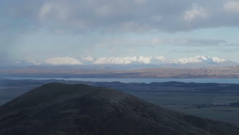 Rango-De-Dos-Pulgares-En-El-Horizonte-Detrás-Del-Lago-Pukaki,-Nubes-De-Tormenta-Tirando