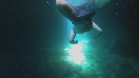 experimentando la impresionante vista de un buzo maniobrando elegantemente bajo el mar azul profundo la luz del sol crea patrones encantadores en el agua clara y brillante