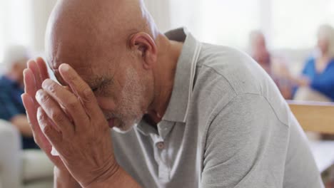 Sad-senior-biracial-man-crying-at-support-group-meeting-of-diverse-senior-friends,-slow-motion