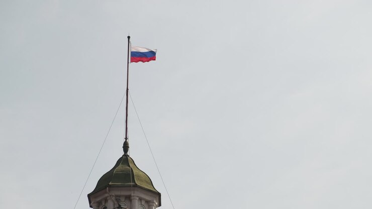 Russian flag waves atop historic Shanghai embassy dome against a clear sky