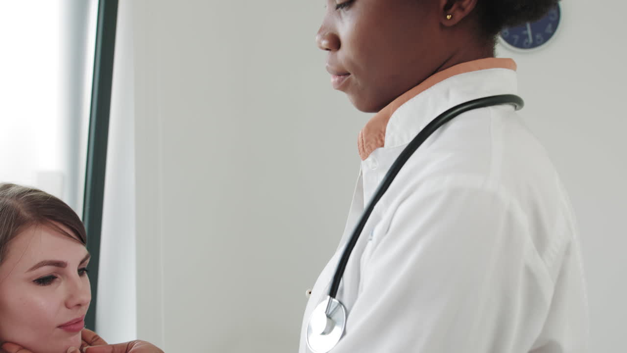 Un professionista del settore medico che visita il collo di un paziente ed esamina le ghiandole durante l'influenza nei giovani