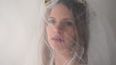the camera tracks in on the bride as she slowly turns to face it. her neutral gaze adds a sense of calm and poise, creating an intimate and serene moment.