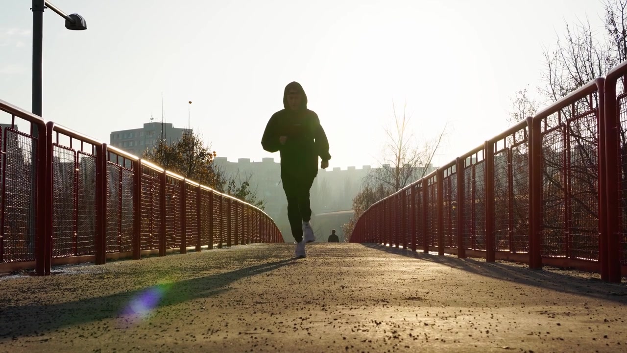 Camminare e correre su un ponte all'alba.