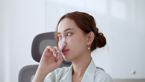 an asian woman thinks about finalizing the concept in her mind for business sustainability in her office