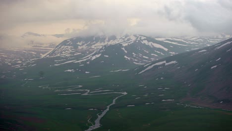 a river winding through the hunza valley landscape with karakoram mountain range in pakistan.