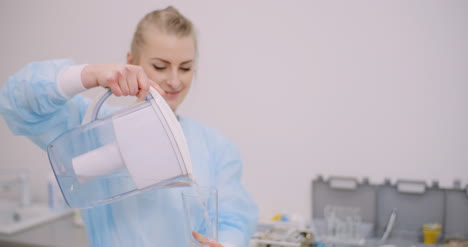 un primerísimo plano de una doctora bebiendo un vaso de agua