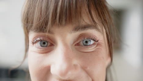 smiling woman with blue eyes looking directly at camera, close-up face shot