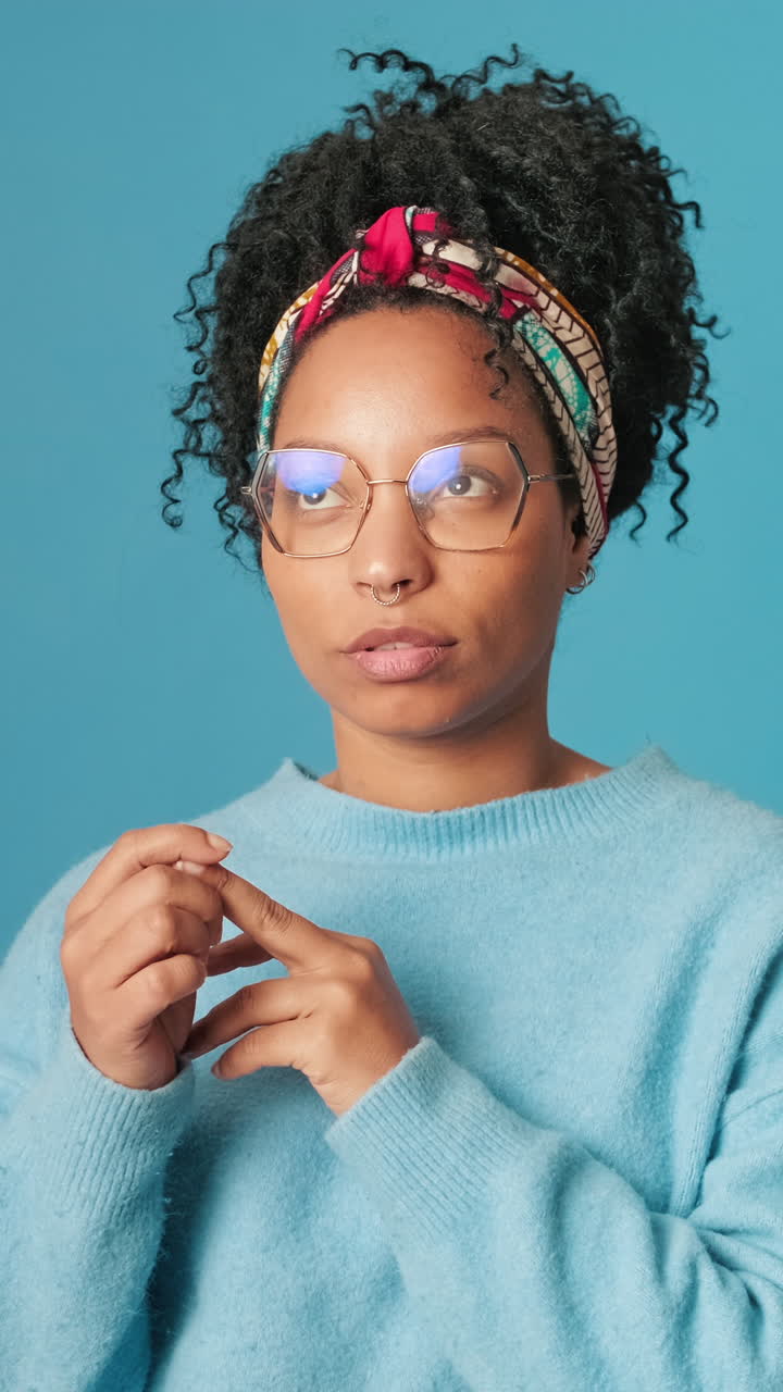 Thoughtful Young Woman Pondering and Counting on Fingers