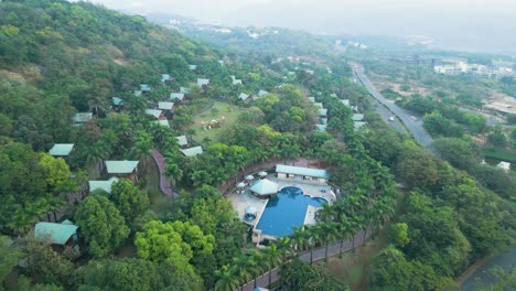 aerial view over a holiday resort at aamby valley city with chalets and a swimming pool in india