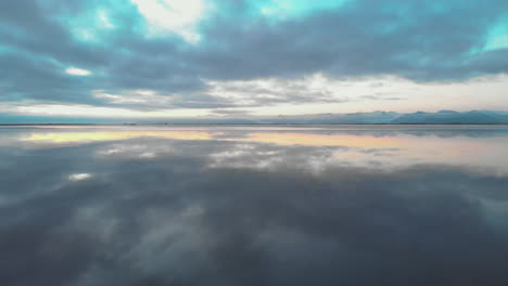 Surreal-mirror-reflection-sunrise-cloudscape-in-calm-Icelandic-ocean-water