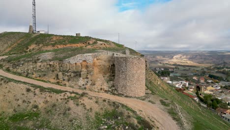 vuelo de avión no tripulado por la mañana sobre una colina donde aparecen los restos de la torre de un castillo del siglo xiv