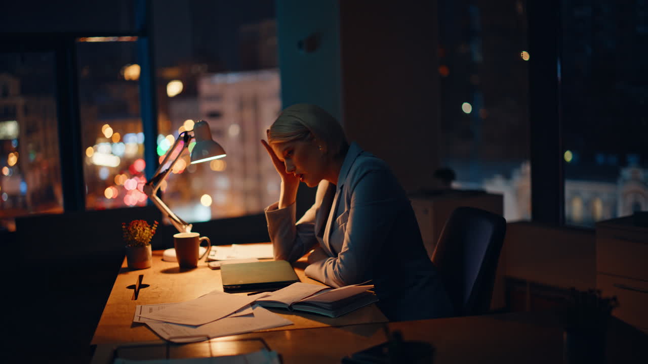 Evening businesswoman drinking espresso sitting office under lamp light closeup