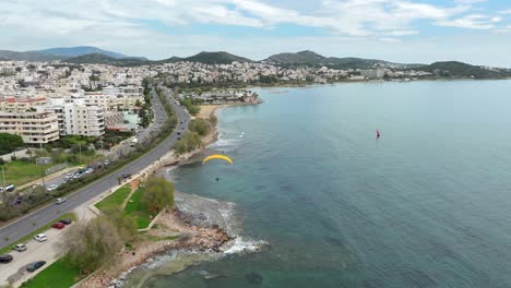 Drone-Flyover-Glyfada-coastline-follow-a-Powered-Paragliding,-Athens