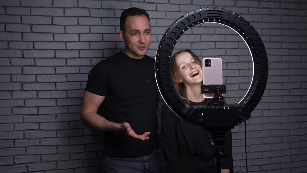 disparo de una pareja de bloggers que cuenta una historia en el fondo de una pared de ladrillo