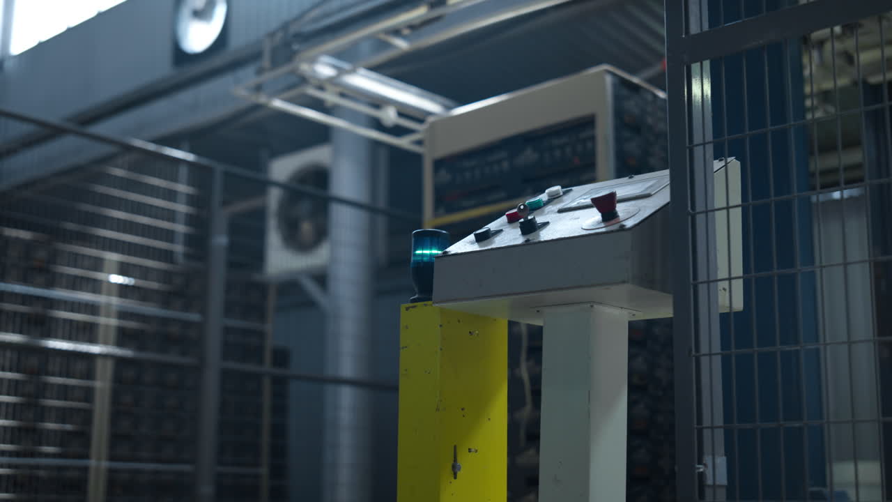 рабочий запускает заводский механизм, тянет рычаг, работает технологическая машина.