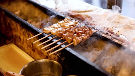 skewers of meat cooking on a smoky grill